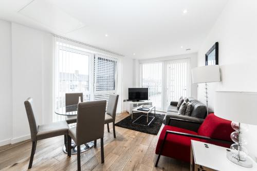 ein Wohnzimmer mit einem Sofa und einem Tisch in der Unterkunft Apartments Near The O2 in London