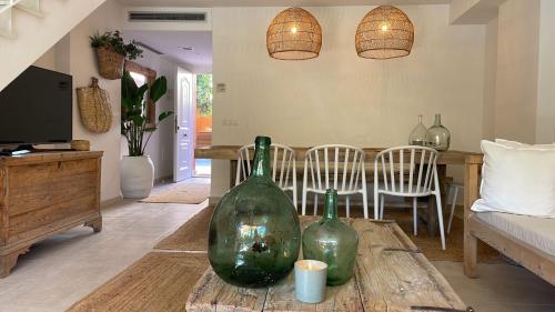 deux bouteilles en verre vert posées sur une table dans un salon dans l'établissement ALOJAMIENTO ARENAL PARK, à Jávea