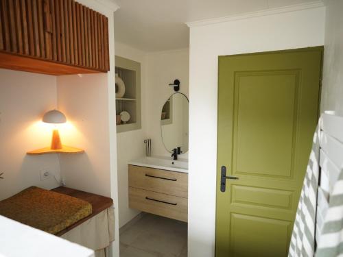 ein Badezimmer mit einer grünen Tür und einem Waschbecken in der Unterkunft CASA ALBA in Solliès-Pont