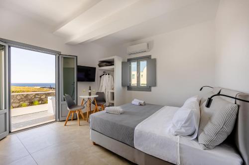 a bedroom with a bed and a view of the ocean at Nastram Suites Oia in Oia