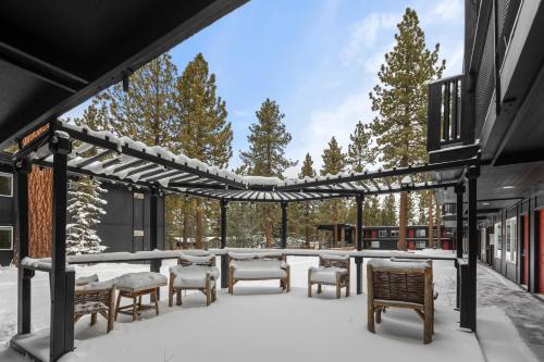 a covered patio with tables and chairs in the snow at Ambassador Lake Tahoe in South Lake Tahoe