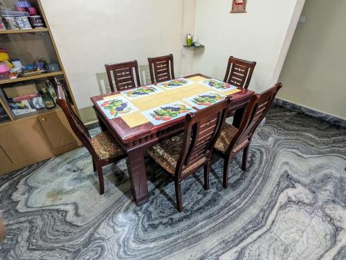 a dining room table with four chairs at Ushuaia- Entire villa, nestled in nature's embrace in Navelim