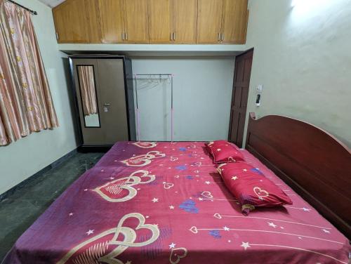 a bed in a room with a purple blanket on it at Ushuaia- Entire villa, nestled in nature's embrace in Navelim