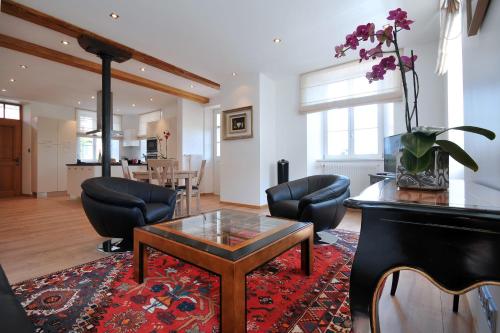 un salon avec une table et des chaises dans l'établissement Les Balcons De Riquewihr, à Riquewihr