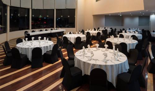 a set of tables in a room with black chairs at Real Inn Tijuana by Camino Real Hoteles in Tijuana