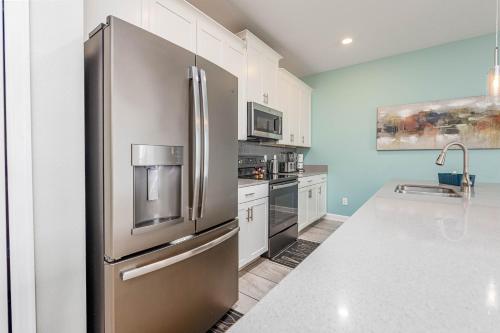 a kitchen with a stainless steel refrigerator and white cabinets at MVP-4967WA SL townhouse in Kissimmee