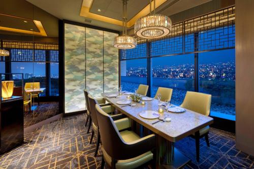 a dining room with a table and chairs and a large window at Nagoya Marriott Associa Hotel in Nagoya