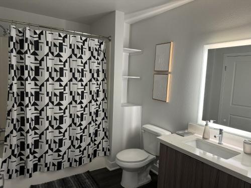 a bathroom with a toilet and a shower curtain at Chic Luxury Condo near Hollywood in Glendale