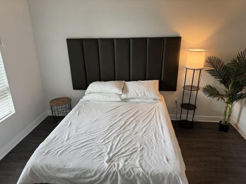 uma cama com lençóis brancos e almofadas num quarto em Chic Luxury Condo near Hollywood em Glendale
