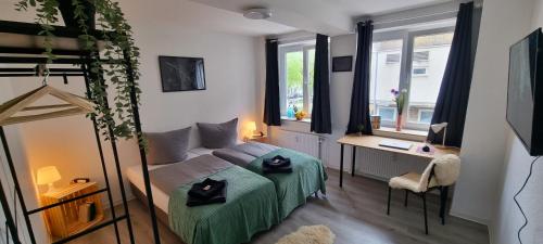 een kleine kamer met een bed, een bureau en een bureau bij Dattel City Hannover FeWo für 4 Personen Privat-Parkplatz 5G WLAN & 24/7 Kontakt in Hannover