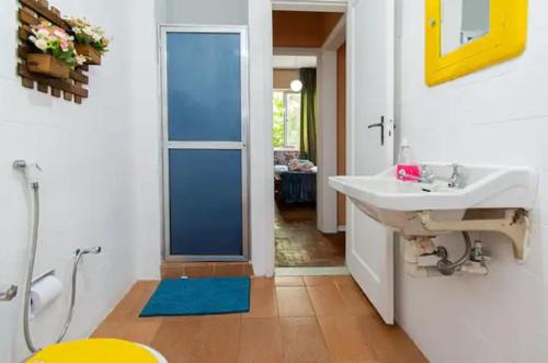 Un baño con lavabo, espejo e inodoro. en Copacabana Pedreira, en Río de Janeiro