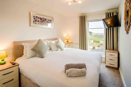 1 dormitorio con 1 cama blanca grande y ventana en Ground Floor Sea View Apartment Private Terrace, en Torquay
