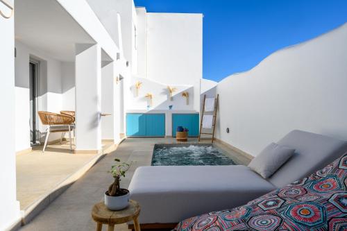 a living room with a couch and a swimming pool at Hypnōs boutique villa with amazing heated pool with jacuzzi in Fira