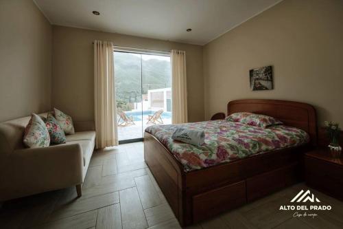 sypialnia z łóżkiem, kanapą i oknem w obiekcie Casa de campo Alto del Prado w mieście Huánuco
