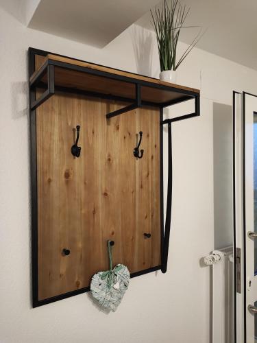 a wooden panel on a wall with hooks on it at FeWo Planer Altstadtwohnung mit Terrasse & Parkplatz in Memmingen