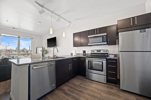 a kitchen with stainless steel appliances and a large window at Downtown View Near Lake Michigan Plaza Black in Milwaukee