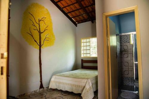 um pequeno quarto com uma árvore pintada na parede em Rancho Divino Espírito Santo- Beira Lago Corumbá IV em Alexânia