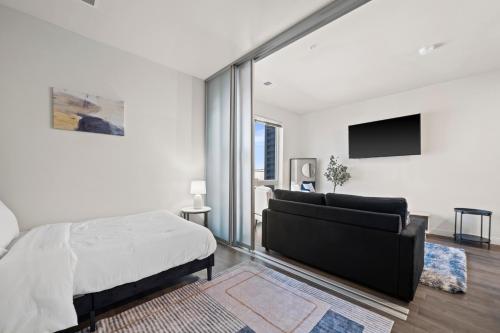 a white bedroom with a bed and a couch at Downtown View Near Lake Michigan Plaza Black in Milwaukee