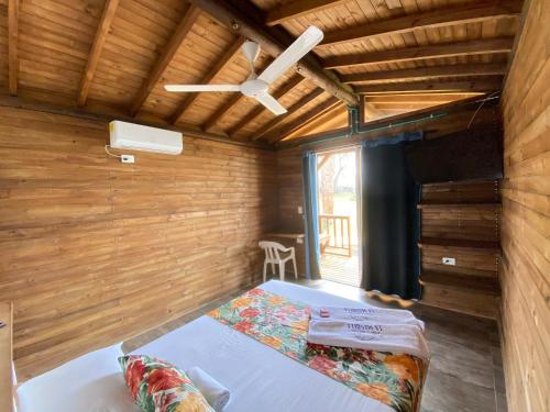 1 dormitorio con 1 cama y ventilador de techo en Finca Hotel La Manuela, en Arboletes