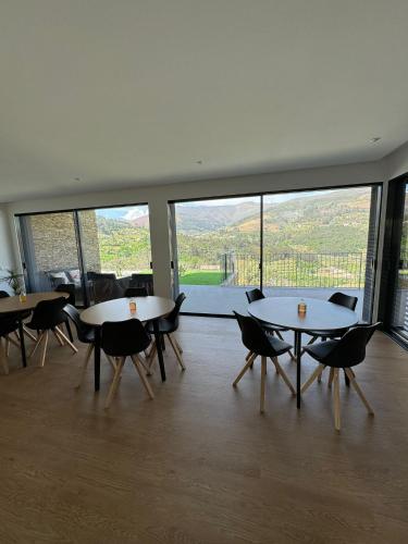 a room with tables and chairs and a large window at Douro - Quinta das Manas - Baião in Alcarias