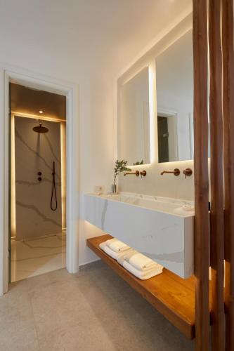 a bathroom with a sink and a mirror and a shower at Phos The Boutique in Akrotiri