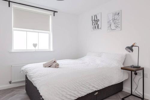 a white bedroom with a bed and a window at Stylish 2 bed flat/Liverpool city/Free parking in Liverpool