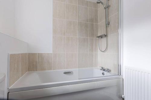 a white bath tub with a shower in a bathroom at Stylish 2 bed flat/Liverpool city/Free parking in Liverpool