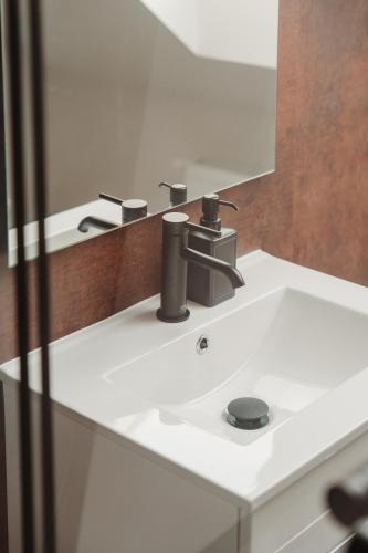 a white sink in a bathroom with a mirror at Hviezdoslavova Apartments, Trnava Centre, Parking available in Trnava