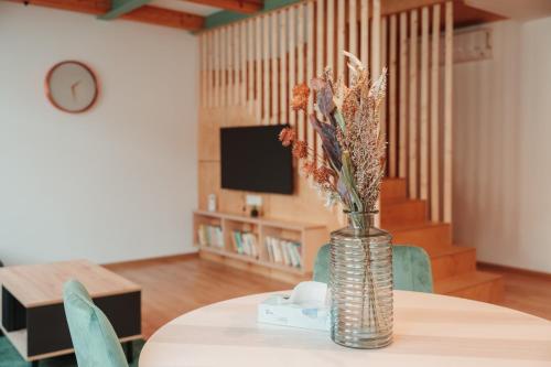 a vase with flowers on a table in a room at Hviezdoslavova Apartments, Trnava Centre, Parking available in Trnava