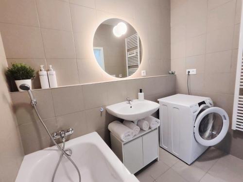 een badkamer met een wastafel en een wasmachine bij Cinnamon - Brand New - Presidential Garden - Free Parking in Bratislava