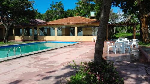 uma casa com piscina, mesa e cadeiras em Hotel e Pousada Marajó em Salvaterra