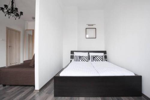 Ce lit se trouve dans un dortoir doté d'un mur blanc. dans l'établissement Stylowy apartament w najlepszej lokalizacji, à Wrocław