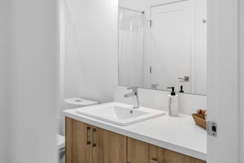 a white bathroom with a sink and a mirror at Cozy tiny home in lake country in Lake Country