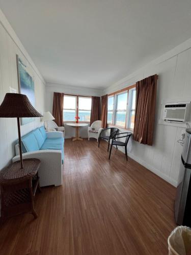 Key Colony Beach Motel في ماراثون: غرفة معيشة مع أريكة وكراسي زرقاء