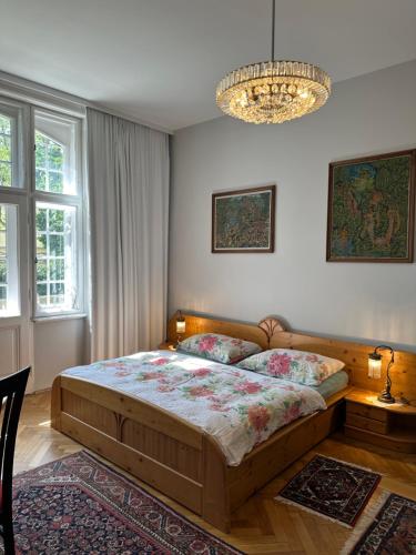 Un dormitorio con una cama grande y una lámpara de araña. en Villa Pazelt Top4, en Bad Vöslau