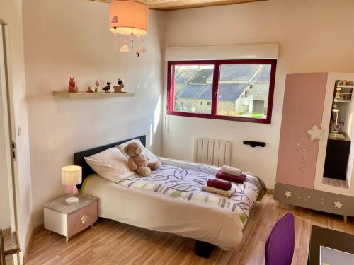 une petite chambre avec un lit avec un ours en peluche dessus dans l'établissement Maison 180m2, jardin clos, 2 terrasses, 5 mn Dinan, à Vildé-Guingalan
