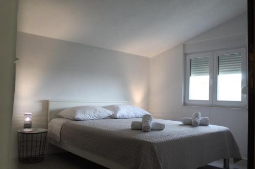 a bedroom with a bed with two towels on it at Apartman Oliva in Posedarje