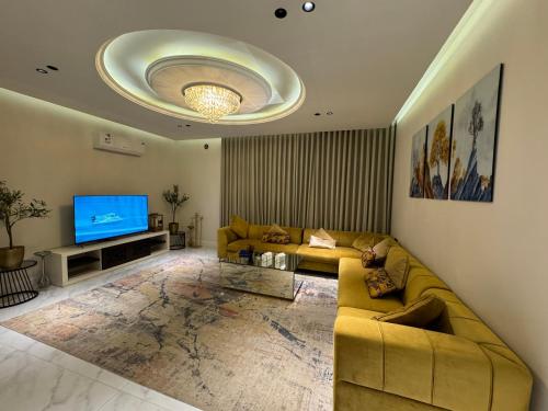 ein Wohnzimmer mit einem Sofa und einem TV in der Unterkunft شقة فاخرة ٣ غرف وصالة ٣ in Riad
