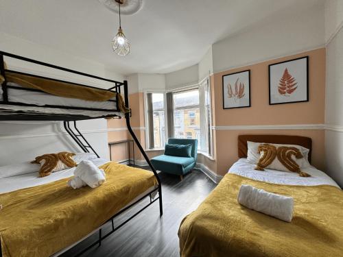 a bedroom with two bunk beds and a blue chair at 4 Bedroom Anfield House, 7 beds, Free Parking, Garden - 5 mins to LFC, 15 mins to City Centre in Liverpool