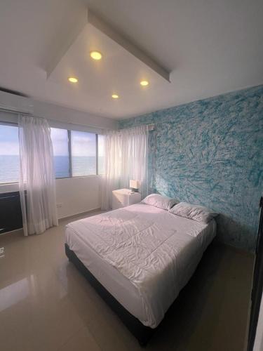 a bedroom with a large bed with a blue wall at Apartamento vista al mar in Cartagena de Indias
