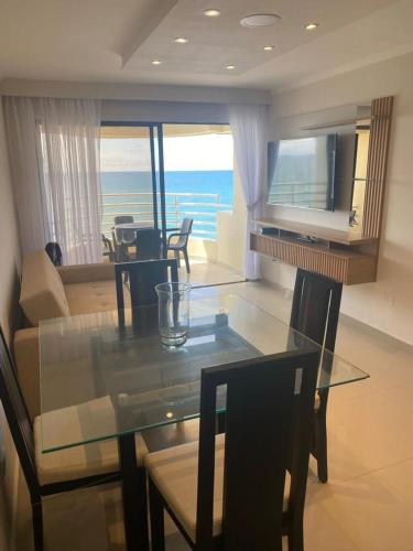 a dining room and living room with a glass table at Apartamento vista al mar in Cartagena de Indias