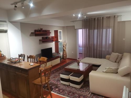 ein Wohnzimmer mit einem Sofa und einem Tisch in der Unterkunft VILI APARTMENTS STAR DOJRAN in Star Dojran