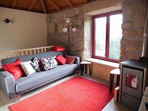 uma sala de estar com um sofá e um tapete vermelho em Nascente, place in nature next to a waterfall em Loureiro