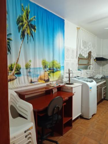 a kitchen with a desk and a palm tree mural at Apartamento das Azaléias térreo in Novo Hamburgo