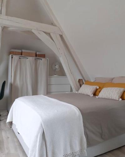 - une chambre avec un lit blanc et une couverture blanche dans l'établissement Charmant et cosy appartement, à Nogent-le-Rotrou