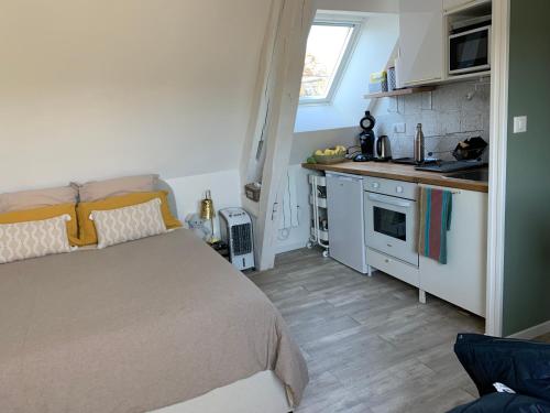 une petite chambre avec un lit et une cuisine dans l'établissement Charmant et cosy appartement, à Nogent-le-Rotrou