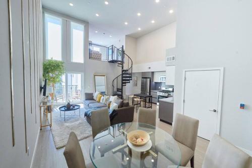 a dining room and living room with a glass table at $3M Penthouse in K-Town with Private Roof Deck in Los Angeles