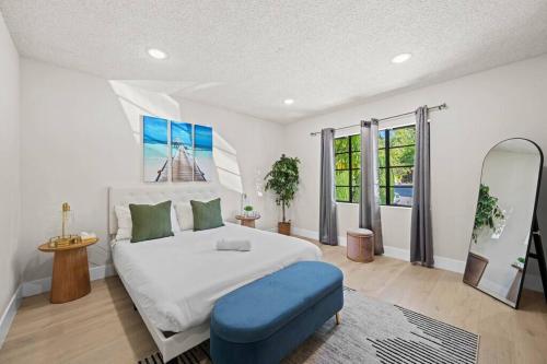 a bedroom with a white bed and a blue stool at Modern Luxe: 4BR Home with Private Jacuzzi in Los Angeles