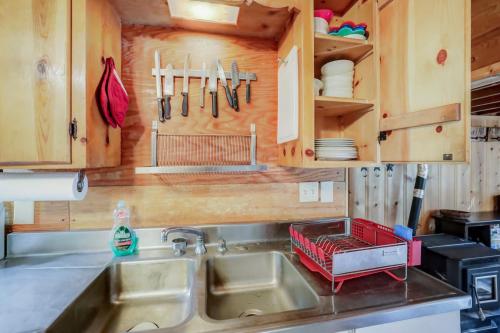a kitchen sink with a red dish rack above it at Spacious Classic Cabin Retreat- near Lassen in Mill Creek
