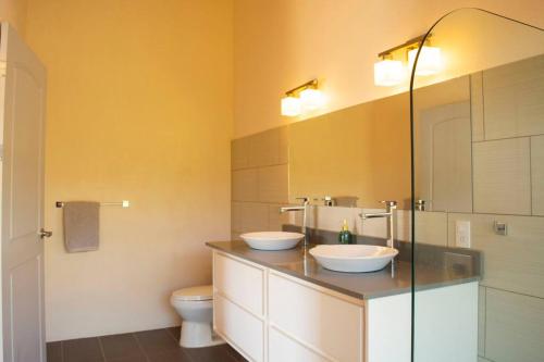 a bathroom with two sinks and a toilet at Villa Saltamontes, ocean view and private pool! in Platanillo